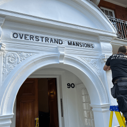 An alarm being fitted on the front of a building