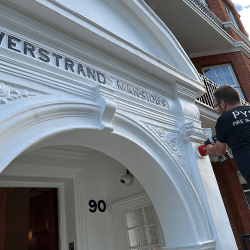 A red alarm being fitted on the front of a building