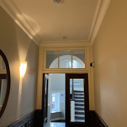 A brown wooden door at the end of a corridor